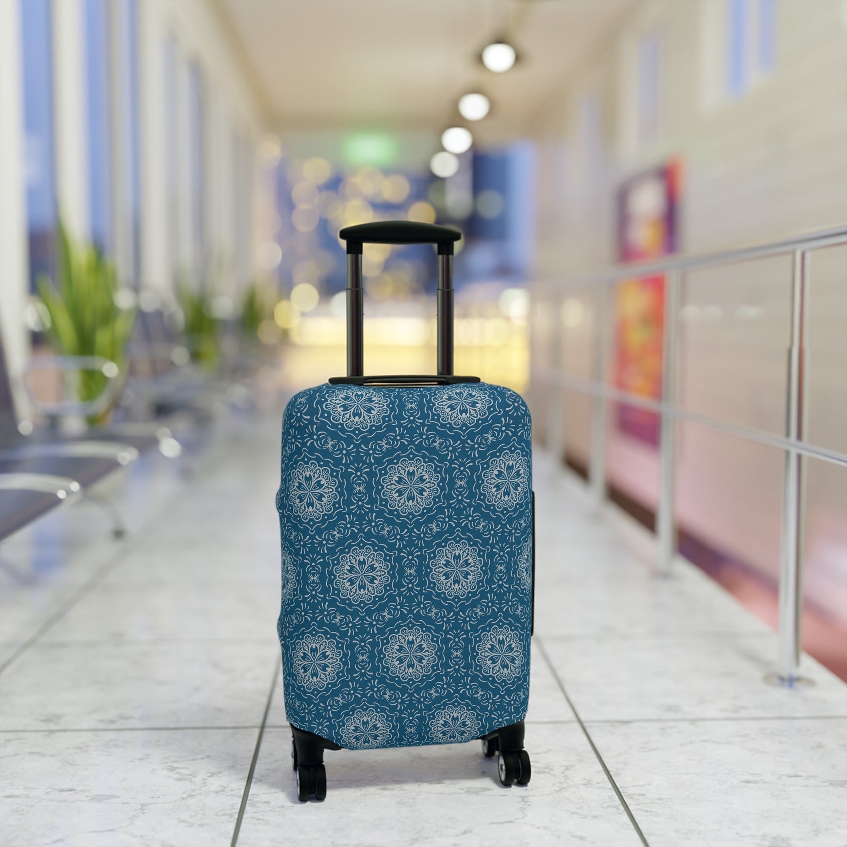 Blue BoHo stretch luggage cover with white mandala pattern fitted on rolling suitcase