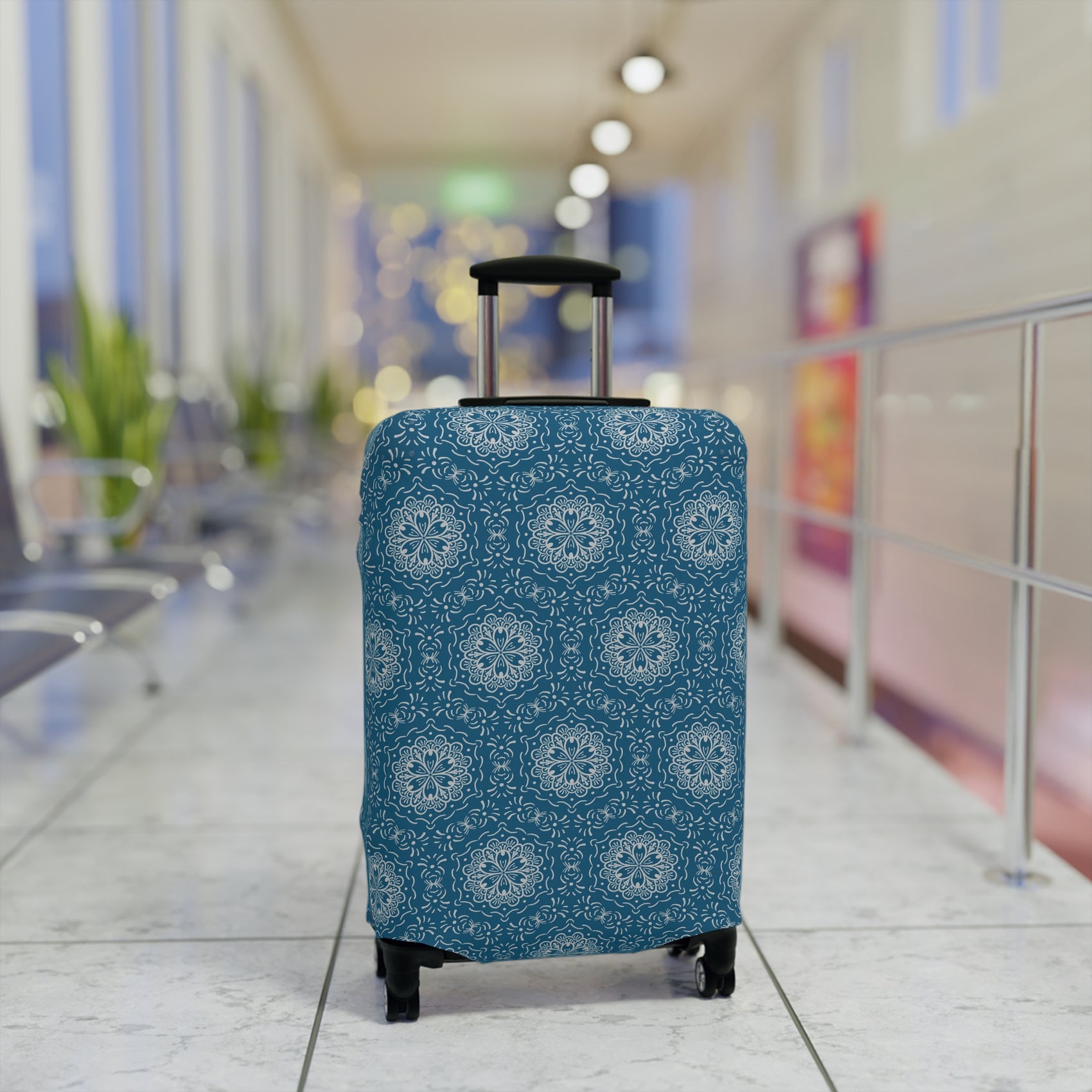 Blue BoHo stretch luggage cover with white mandala pattern fitted on rolling suitcase