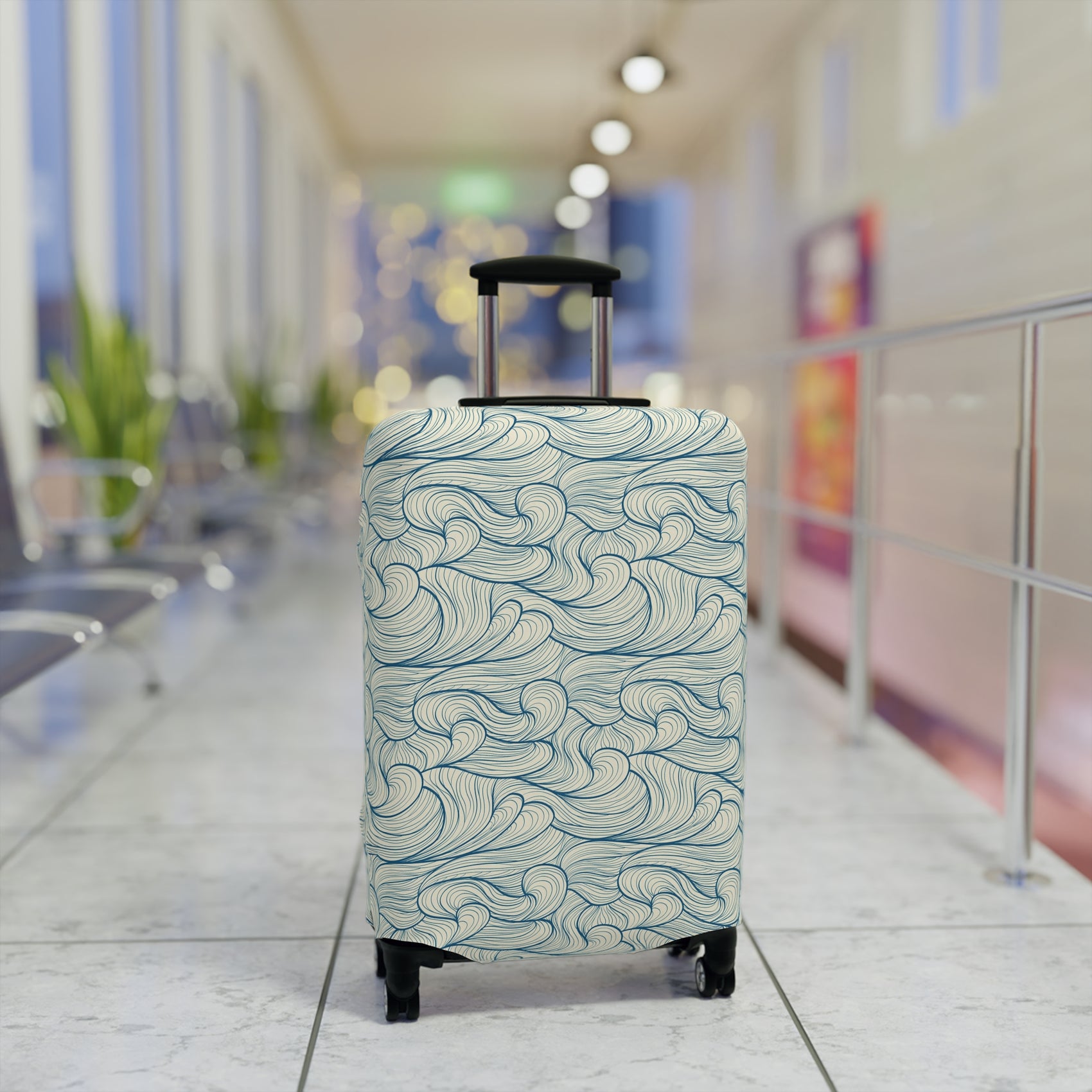 Blue wave patterned stretch luggage cover protecting a rolling suitcase