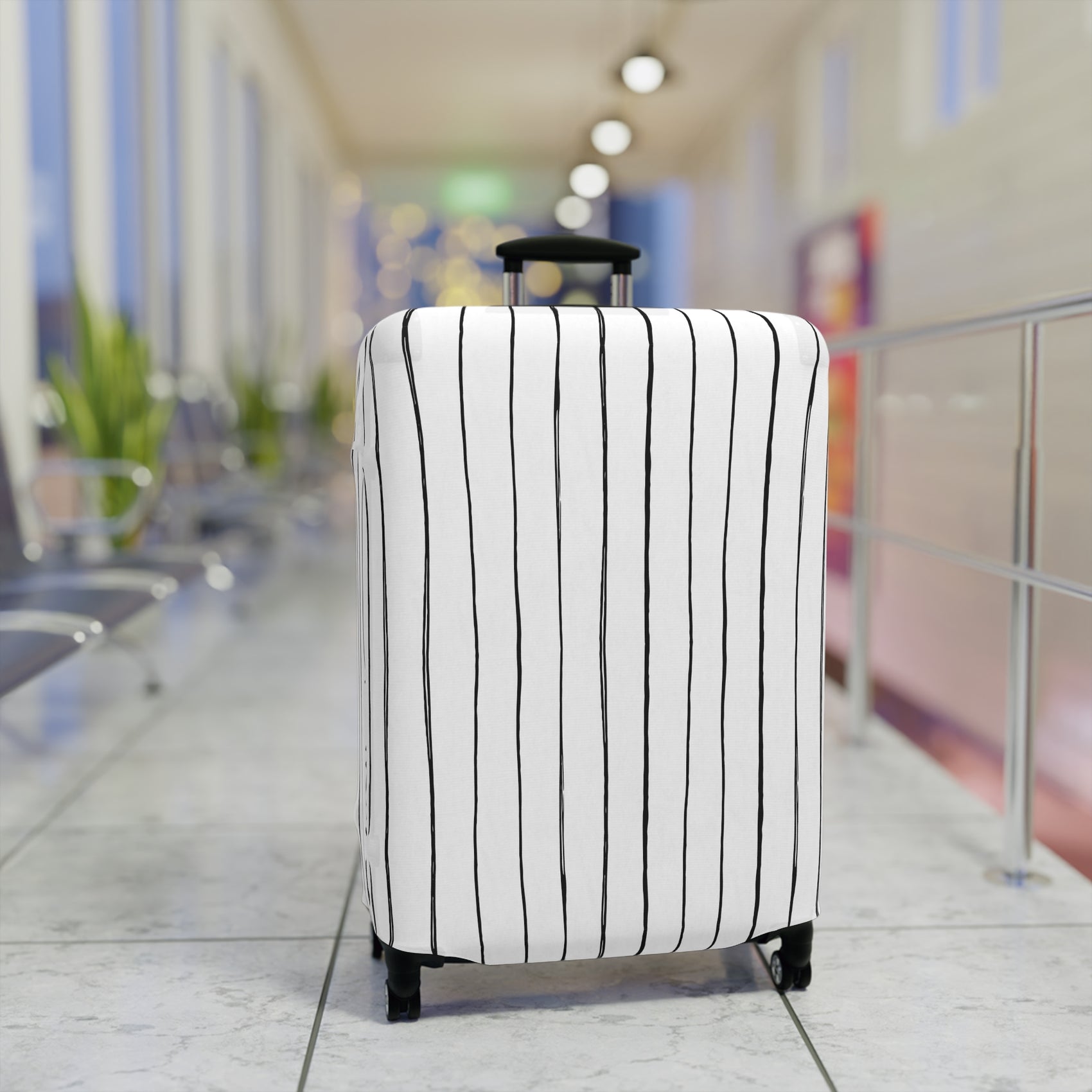 Black and white striped stretch luggage cover with zipper closure protecting a rolling suitcase