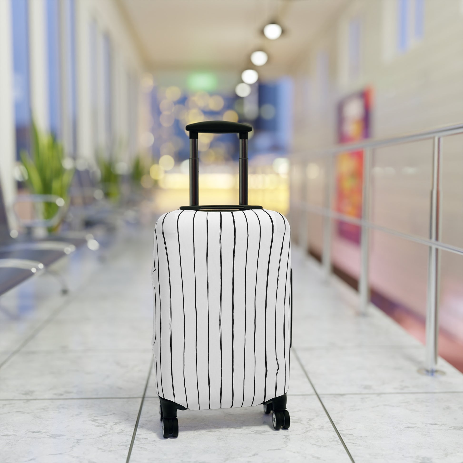 Black and white striped stretch luggage cover with zipper closure protecting a rolling suitcase