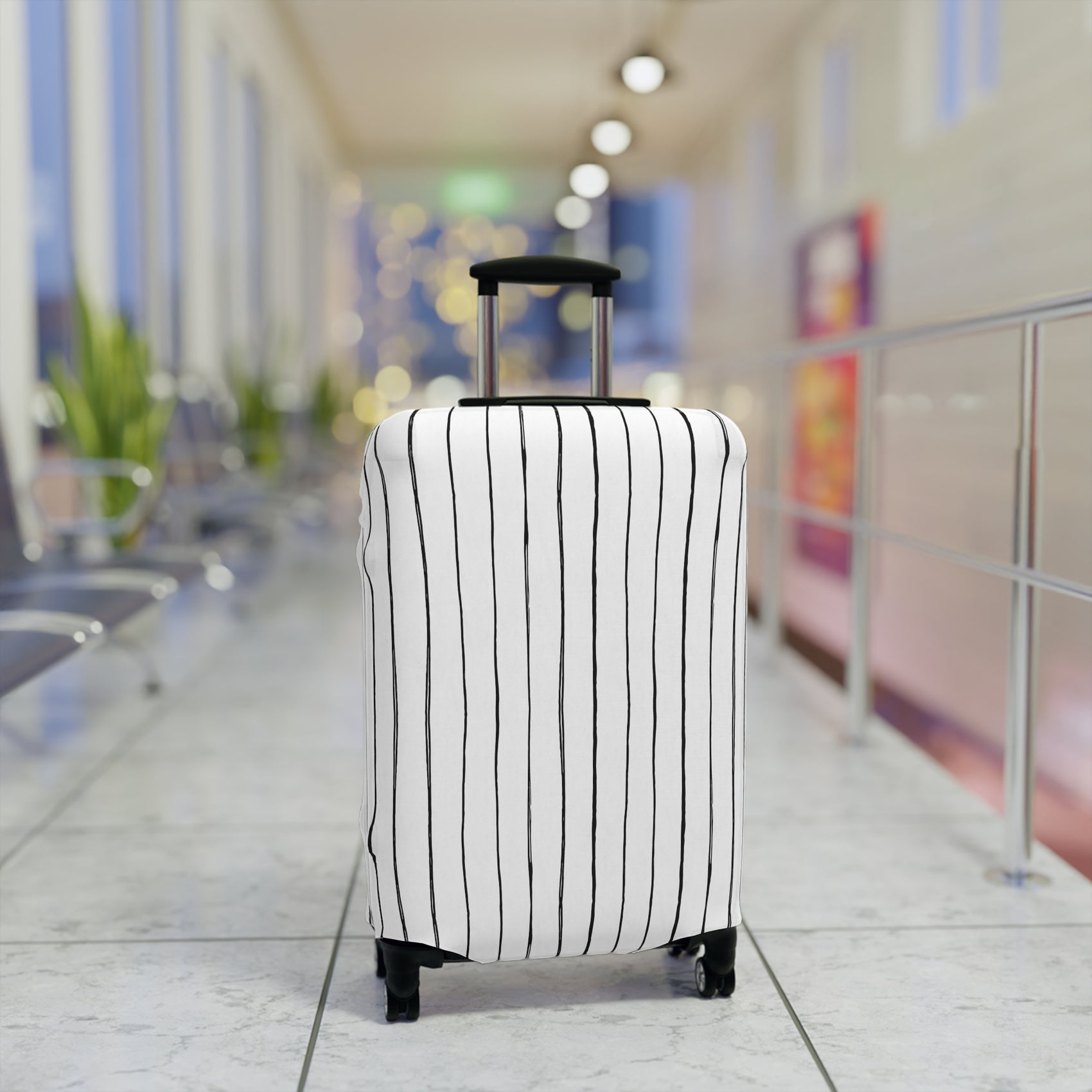 Black and white striped stretch luggage cover with zipper closure protecting a rolling suitcase