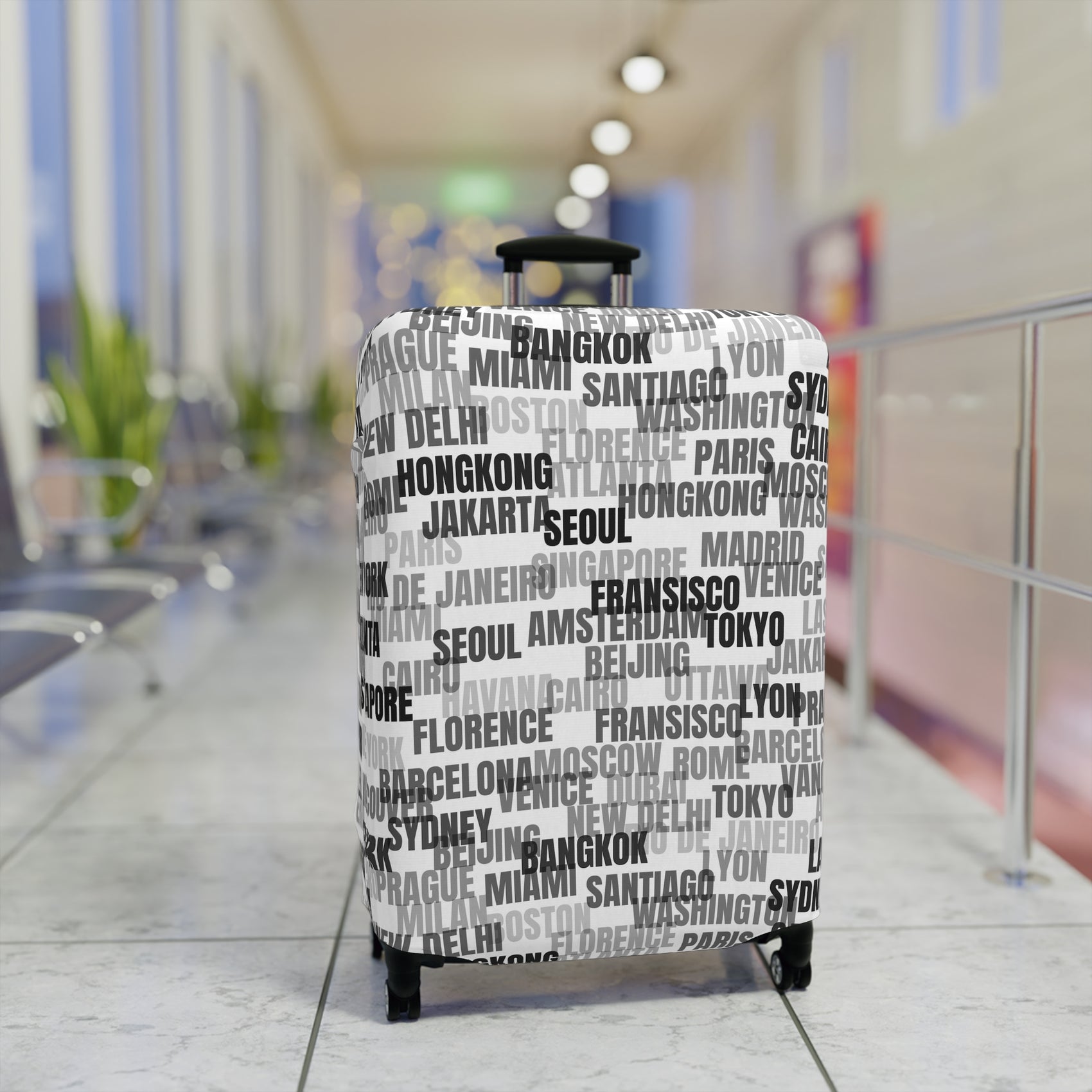 World in Motion white luggage cover with black city name typography fitted on rolling suitcase