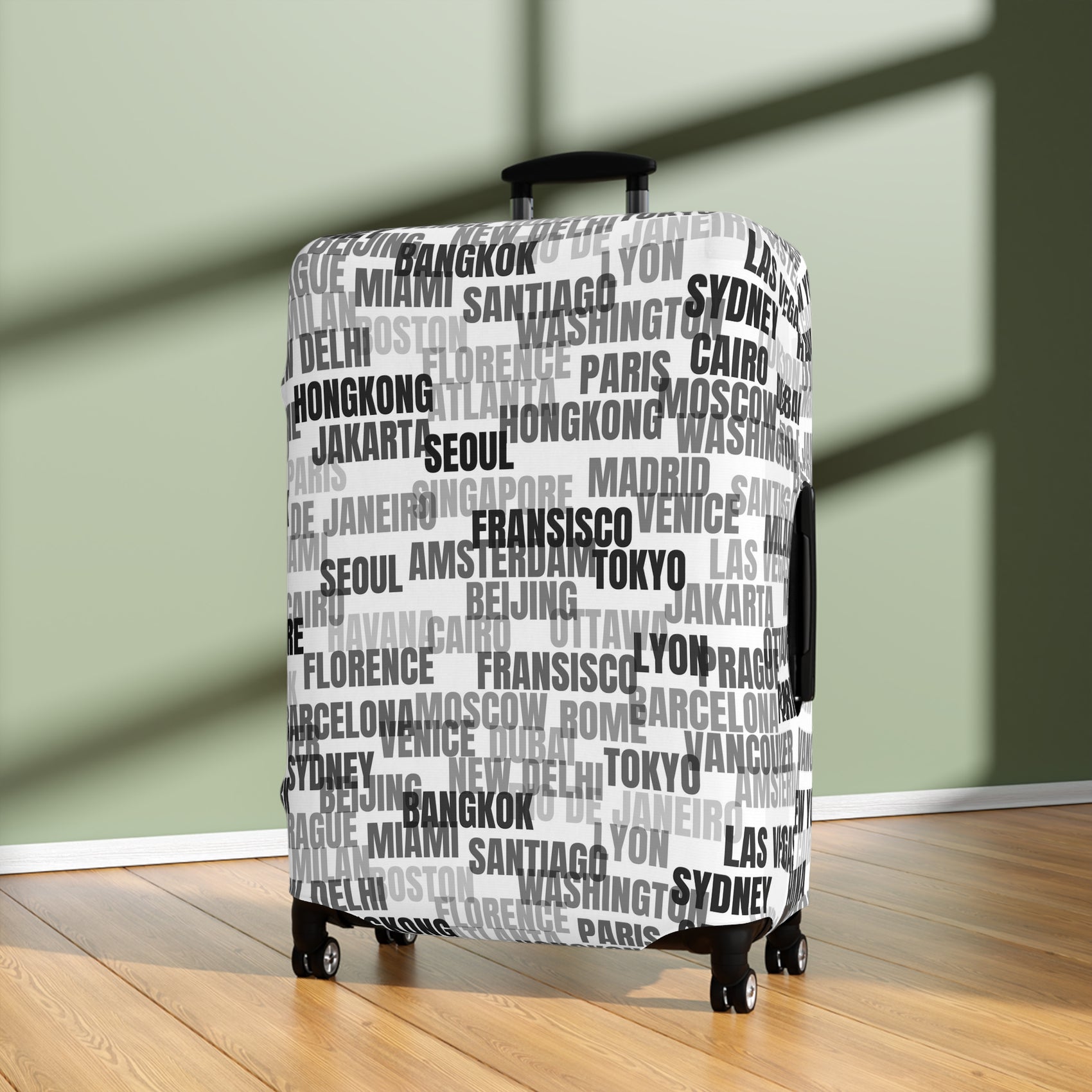 World in Motion white luggage cover with black city name typography fitted on rolling suitcase