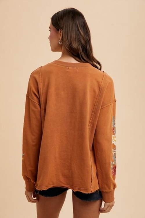 Embroidered Long Sleeve French Terry Top - Front View Cozy and Stylish Cotton Pullover with High-Low Hem Elegant Embroidery Detail on Soft French Terry Fabric Exposed Seam and Ribbed Accents on Casual Pullover Long Sleeve French Terry Sweatshirt Styled for Everyday Wear