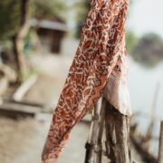 Hand-Dyed Cotton Scarf Naturally Dyed with Avocado and Madder Eco-Friendly Lightweight Cotton Scarf Draped Over Shoulders Soft Cotton Scarf in Earthy Tones with Natural Dye Variations Ethically Made Handwoven Scarf Styled as a Headwrap USA-Made Sustainable Fashion Scarf in Soft Cotton